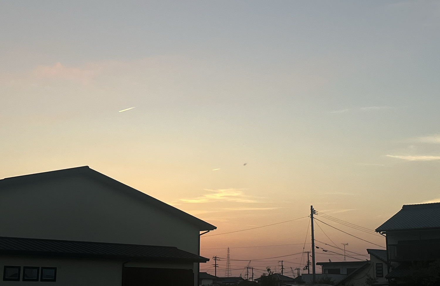 飛行機雲の見えるある日の夕暮れ